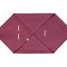 Die KraftKids Babydecke für Babyschale Sommer Leinen in magenta dunkel hat eine sechseckige Form mit weißen Nähten, zwei Paar parallele Knopflöcher und ein kleines weißes Etikett an einer Kante, flach auf weißem Hintergrund.