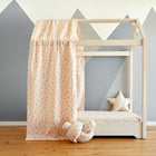 Ein minimalistisches Kinderbett mit hellem Holzrahmen, KraftKids Bettbaldachin Musselin Kirschen, Sternkissen und geknotetem Kissen. Die graue geometrische Bergwand vervollständigt diesen Look - perfekt mit stilvollen Kinderzimmer Accessoires.