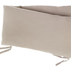 Zwei beigefarbene "Bettumrandung Nestchen Musselin"-Kissen von KraftKids aus atmungsaktiver Baumwolle mit dezentem Strukturmuster und Stoffbändern an den Ecken sind leicht versetzt vor einem weißen Hintergrund gestapelt.