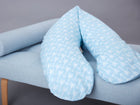 Das KraftKids qualitäts Stillkissen weiße Pfeile auf Blau mit ergonomischer Form ruht auf einer hellblau gepolsterten Bank mit Holzbeinen, die vor einem grauen Hintergrund stehen.