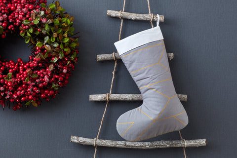 Lignes d'or de chaussette de Noël sur le gris