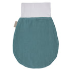 Ein KraftKids Strampelsack Frühling Sommer Musselin nilblau, oval mit weißem dehnbarem Bund und kleinem beigen Seitenanhänger, liegt flach auf weißem Grund.