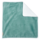 Eine rechteckige mintfarbene Wickelunterlage Cord Breitcord von KraftKids mit dezent gestreifter Struktur und weißem Rand wird flach hingelegt, eine Ecke gefaltet, um eine weiche, wasserundurchlässige Unterlage in Weiß darunter zu enthüllen.