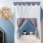 Das KraftKids Puppentheater Kasperletheater Musselin grau Punkte inkl.. Teleskopstange steht hinter violetten Vorhängen vor einer blauen Wand, links eine Strohsonne mit lachendem Gesicht neben einer Tafel mit bunten Zeichnungen.